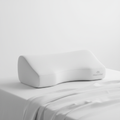 Nocturely Memory Foam Contour Pillow white ergonomic shape on a crisp white bed with soft linen