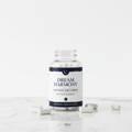 Nocturely Magnesium Sleep Supplement dark navy and white bottle on white marble surface with soft ambient lighting