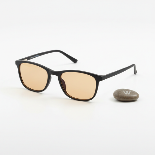 Nocturely Blue Light Blocking Glasses with amber-tinted lenses and matte black frame on a clean white surface