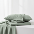 Nocturely Bamboo Bed Sheet Set in soft sage green neatly folded on a white surface